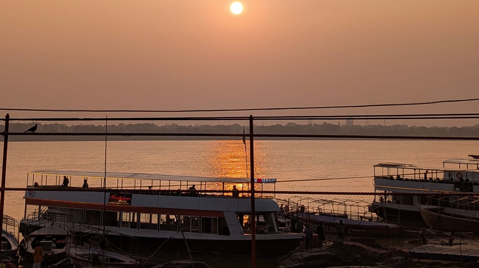 Golden sunset over the Ganges with boats parked along the riverbank in Varanasi