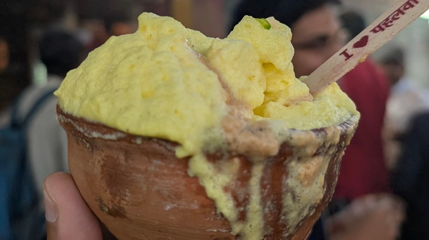 Thick creamy Pahalwan lassi overflowing from a kulhar (clay cup) in Banaras