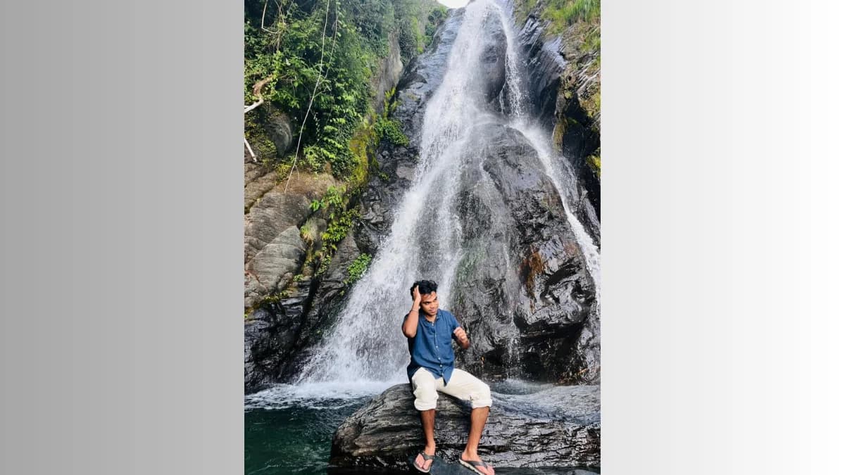Bhagsu Waterfall cascading down rocks near McLeodganj with mist rising and lush green surroundings